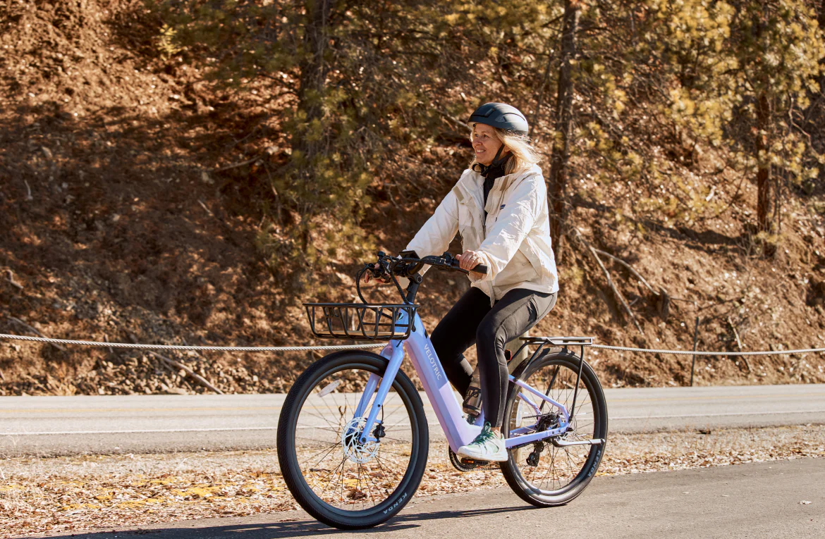 Girl riding a bicycle on a road with a natural background